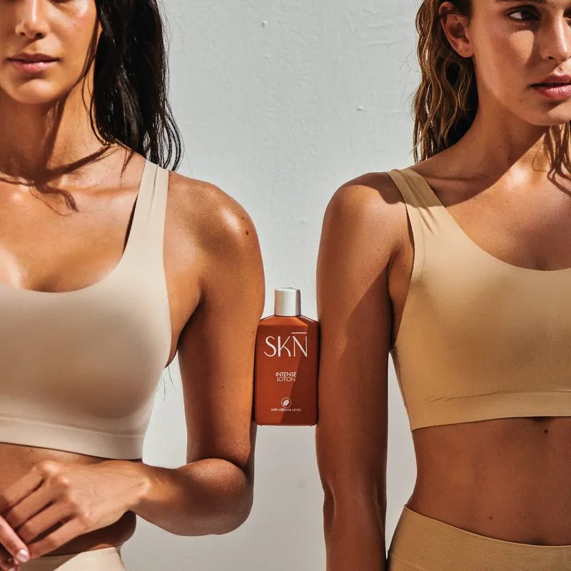 The SKN lotion family, photographed in hand.